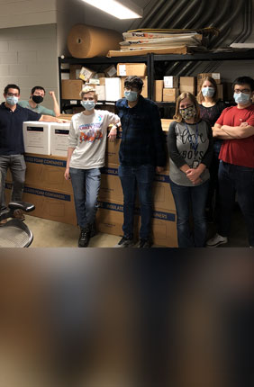 From left: Max Simon, Kyle Shelton, Laura Daigh, Auroni Gupta, Jana Radin, Katie Frye, and Xiaorui Guo stand next to a shipment of viral transfer media (VTM) prior to shipment. The group was among the almost 50 volunteers at Illinois who helped produce enough VTM for 200,000 COVID-19 tests.