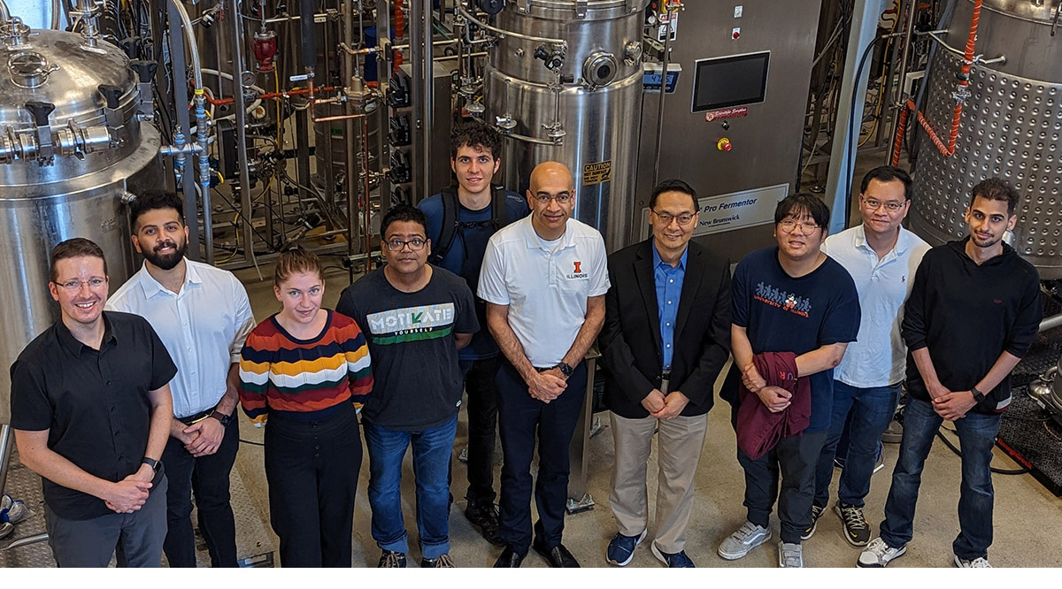Illinois research team in front of a fermenter at IBRL