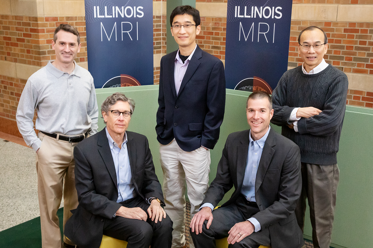 Scientists at the University of Illinois Urbana-Champaign developed a method to noninvasively image DNA methylation, allowing new explorations of the mechanisms that regulate gene expression in the brain. The team includes, from left, chemistry professor Scott Silverman; entomology professor Gene Robinson, the director of the Carl R. Woese Institute for Genomic Biology; bioengineering professor Fan Lam; animal sciences professor Ryan Dilger; and electrical and computer engineering professor Zhi-Pei Liang.