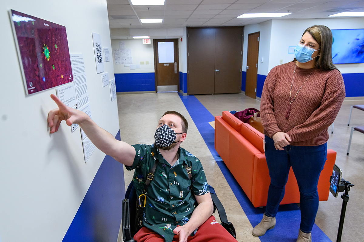 Ph.D. student Brian Graves created a video game that pits players against invading viruses. He presents his ideas to Whitney Greger, the Champaign-Urbana Public Health District director of wellness and health promotion.
