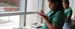 Campers take notes on their plant growth experiment results.