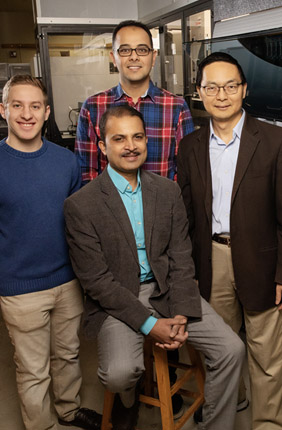 Scott Weisberg, left, professor Saurabh Sinha, seated, Mohammad (Sam) Hamedi Rad and professor Huimin Zhao have combined a fully automated robotic platform with artificial intelligence to develop a new way to manufacture chemicals.