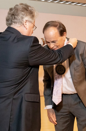 Provost Andreas Cangellaris places a medallion around the neck of Ikenberry Endowed Chair Stephen Long in recognition of his investiture. 