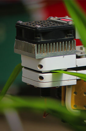 Photo of infra-red gas analyzer and a rice leaf. The leaf is placed inside a cuvette in which conditions related to light intensity, CO2 concentration, relative humidity, and temperature can be controlled. 