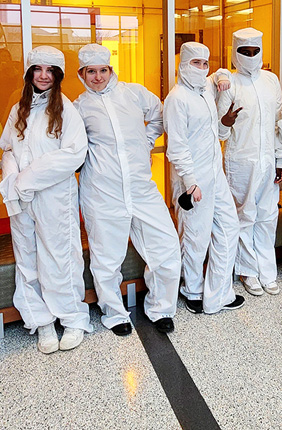 Students from Campus Middle School for Girls try on protective gear called "bunny suits" in front of the cleanrooms within the Nick Holonyak Micro and Nanotechnology Laboratory.