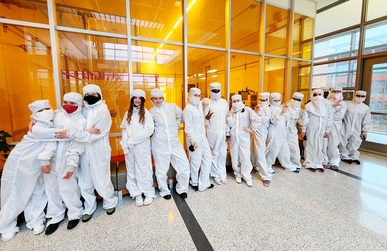 Students from Campus Middle School for Girls try on protective gear called "bunny suits" in front of the cleanrooms within the Nick Holonyak Micro and Nanotechnology Laboratory.