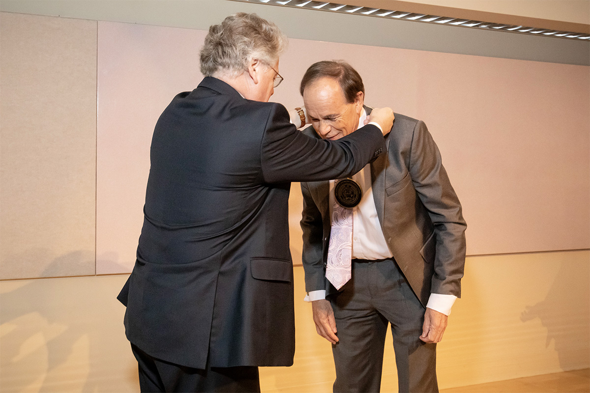 Provost Andreas Cangellaris places a medallion around the neck of Ikenberry Endowed Chair Stephen Long in recognition of his investiture. 